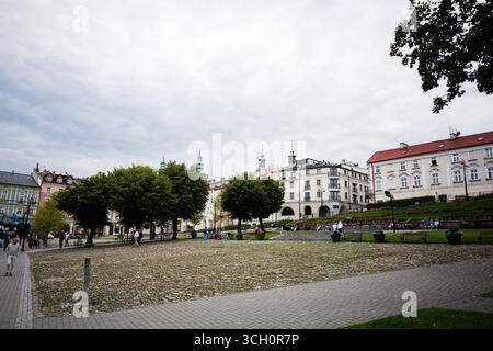 Przemysl, Polen - 23. August 2025: Bezaubernder Platz in Przemysl, Polen mit Grün, klassischen Gebäuden und Kopfsteinpflasterpfaden Stockfoto