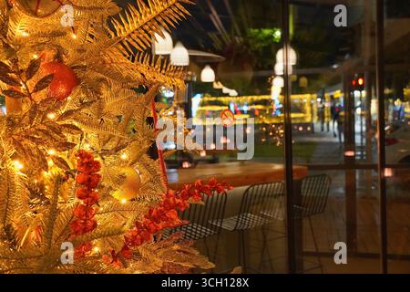 Ein Weihnachtsbaum mit roten Ornamenten und Lichtern in einer Bar in Glyfada, Athen, Griechenland Stockfoto