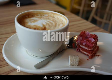 Köstlicher Kaffee mit einem kleinen Stück rotem Samtkuchen Stockfoto