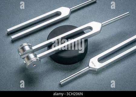 Satz gewichteter und ungewichteter Stimmgabeln aus Metall, die zum Abstimmen von Musikinstrumenten, zur Klangtherapie, zur Chakra-Heilung oder -Entspannung, zum Hockey Puck Actova verwendet werden Stockfoto