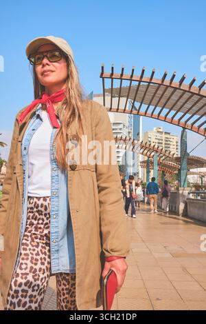 Touristenwanderung in miraflores, lima, mit modernen Gebäuden, Palmen und El Beso Statue im Hintergrund Stockfoto