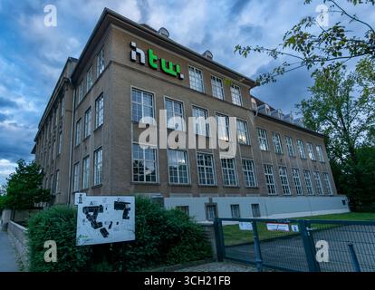 Historisches Gebäude des HTW Berlin Campus Karlshorst, von der Straße aus gesehen mit Abendhimmel und Eingangsbeschilderung. Stockfoto