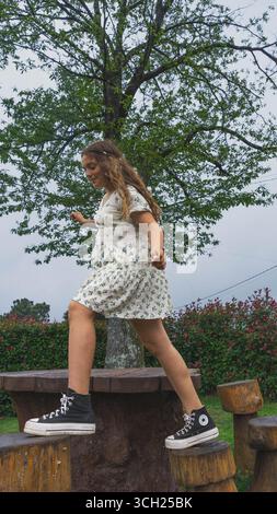 Junge Frau, die auf Holzstümpfen läuft Stockfoto