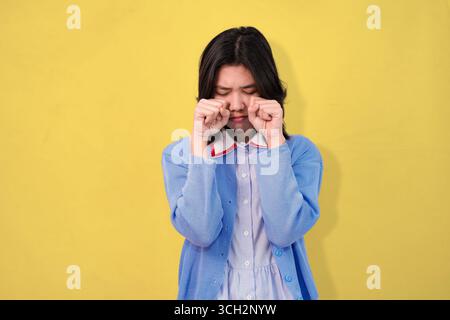 Junge Frau, die weint und traurig posiert, im Studio-Hintergrund Stockfoto
