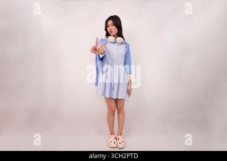 Legere junge Frau in entspannter Pose in einem stilvollen Outfit Stockfoto