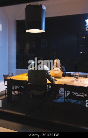 Geschäftsleute diskutieren bei nächtlichen Besprechungen im modernen Büro über das Projekt Stockfoto