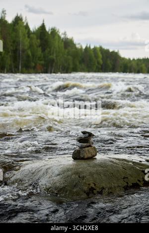 Eine ruhige Flusslandschaft mit Balanced Stones, elegant gelegen inmitten des fließenden Wassers Stockfoto