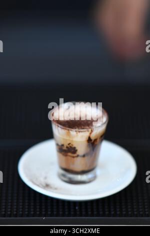 Cremona, Italien - 21. Juli 2025 Ein kleiner, köstlicher Kaffee mit Creme und Schokoladenpulver, auf der Oberseite bestreut, serviert in einem Glas Stockfoto