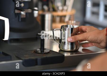 Cremona, Italien - 21. Juli 2025 Barista bereitet sich auf die Kaffeezubereitung vor. Aufschäumende Milch im Metallkrug mit Espressomaschine im Café Stockfoto