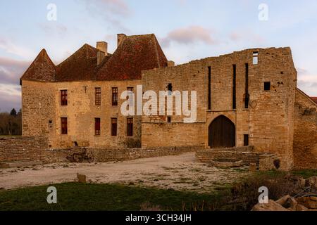 Frontalansicht des Château d'Eguilly in Eguilly, Frankreich, beleuchtet durch das warme, goldene Licht des Sonnenuntergangs. Stockfoto