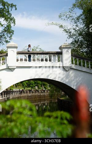 Junge weibliche Touristen, die die Aussicht von einer Brücke in einem Park bewundern Stockfoto