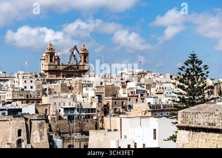 Cospicua, Malta - 11. April 2025: Blick auf die Kirche der Unbefleckten Empfängnis und traditionelle maltesische Gebäude im historischen Dreistädtegebiet Stockfoto