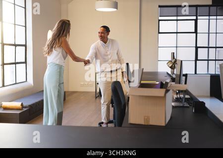 Vielseitige Geschäftsleute schütteln in modernen Büros die Hände und besiegeln damit einen erfolgreichen Abschluss Stockfoto