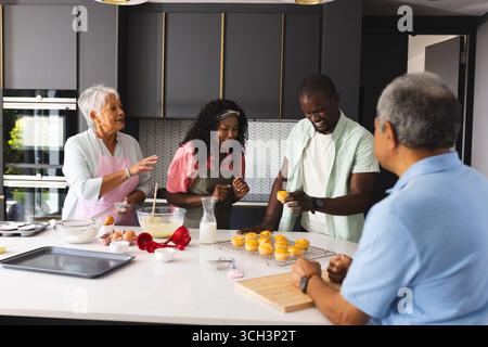 Fröhliche Familienbacken in der modernen Küche, Lachen und Dekorieren von Cupcakes, zu Hause Stockfoto