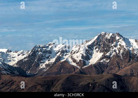 Frankreich - Saint-Lary-Soulan - Pyrenäen - schneebedeckte Gipfel der Pyrenäen erheben sich vor einem trüben blauen Himmel. Stockfoto