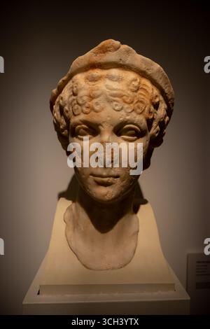 Merida, Spanien - 3. April 2023: Alte Marmorbüste einer jungen Frau mit lockigem Haar und Stirnband. Stockfoto