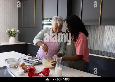 Gemeinsam in der Küche backen, Großmutter und Enkelin teilen einen freudigen Moment Stockfoto