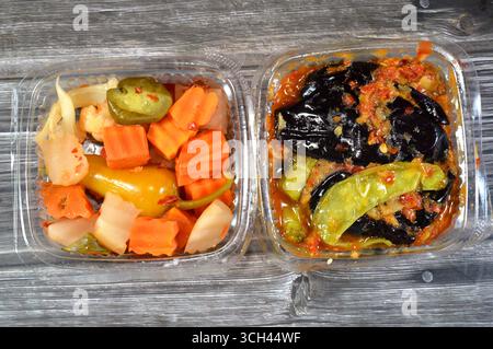Verschiedene eingelegte Gurken aus gebratener Aubergine und grüner Paprika gefüllt mit Knoblauch, rotem Chili, Essig, Zitrone und marinierter Paprika Stockfoto