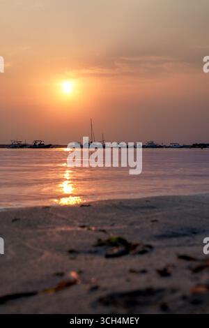 Ein ruhiger Sonnenuntergang über dem ruhigen Wasser bietet eine wunderschöne Aussicht auf Formentera, Balearen, Spanien. Stockfoto