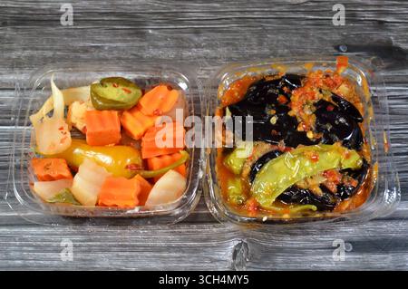 Verschiedene eingelegte Gurken aus gebratener Aubergine und grüner Paprika gefüllt mit Knoblauch, rotem Chili, Essig, Zitrone und marinierter Paprika Stockfoto