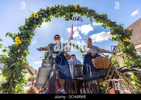 31. August 2025, Brandenburg, Burg (Spreewald): Frauen in traditionellen Spreewalderkostümen nehmen im Rahmen des Heimatfest Geschichte und Trachtenfestes auf dem Fahrrad an der traditionellen Parade durch das Zentrum von Burg teil. Foto: Frank Hammerschmidt/dpa Stockfoto