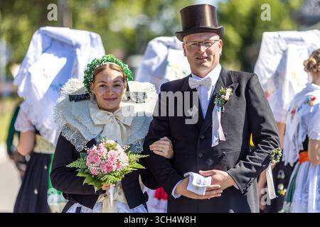 31. August 2025, Brandenburg, Burg (Spreewald): Zwei Teilnehmer der Parade im Rahmen des lokalen und traditionellen Trachtenfestes im traditionellen Burger-Hochzeitskostüm gekleidet. Foto: Frank Hammerschmidt/dpa Stockfoto