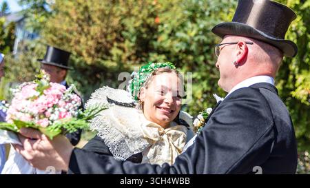 31. August 2025, Brandenburg, Burg (Spreewald): Zwei Teilnehmer der Parade im Rahmen des lokalen und traditionellen Trachtenfestes haben sich in traditionellen Burger Hochzeitskostümen verkleidet und tanzen. Foto: Frank Hammerschmidt/dpa Stockfoto