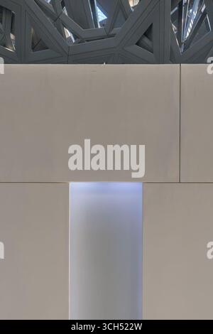 VAE - Abu Dhabi - Louvre Abu Dhabi - minimale Wand und leuchtende Nische unter dem gemusterten Baldachin Stockfoto