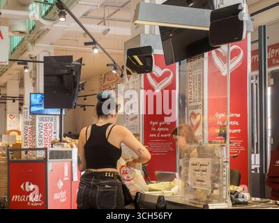 Cremona, Italien - 14. August 2025 Kunde kauft Lebensmittel an der Kasse in einem modernen Supermarkt-Innenraum während eines typischen Einkaufs Stockfoto