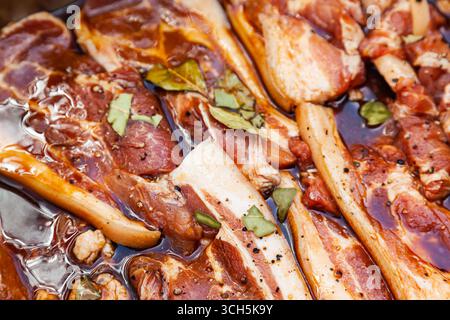Speck in Salzlake mit Gewürzen. Schweineschnitzel in Salzlake mit Gewürzen eingeweicht. Stockfoto