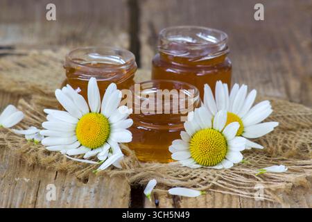 Honig und Blumen auf Holzhintergrund Stockfoto