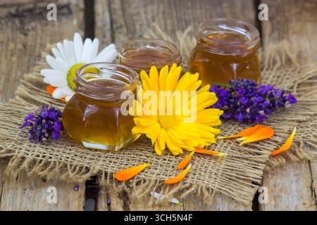 Honig und Blumen auf Holzhintergrund Stockfoto