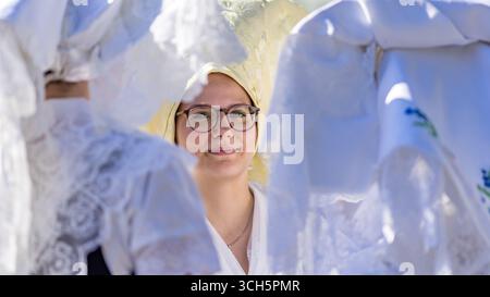 31. August 2025, Brandenburg, Burg (Spreewald): Die mit Kapuzen geschmückten Teilnehmer stehen zusammen bei der Trachtenparade im Rahmen des Lokal- und Trachtenfestes. Foto: Frank Hammerschmidt/dpa Stockfoto