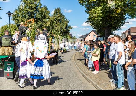 31. August 2025, Brandenburg, Burg (Spreewald): Menschen mit vielen Zähnen beobachten den traditionellen Umzug durch das Zentrum von Burg vom Straßenrand aus im Rahmen des Heimatfest Geschichte und Trachtenfestes. Foto: Frank Hammerschmidt/dpa Stockfoto