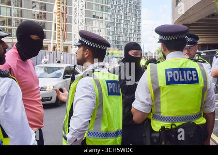 London, Großbritannien. 31. August 2025. Antimigrantische, maskierte Gegenprotestierende werden von Polizisten zurückgehalten, während sich Demonstranten vor dem Britannia International Hotel in Canary Wharf zur Unterstützung von Migranten versammeln, wo Asylsuchende untergebracht sind, Teil der laufenden Demonstrationen im Zusammenhang mit Migranten, die in ganz Großbritannien stattfinden. Quelle: Vuk Valcic/Alamy Live News Stockfoto