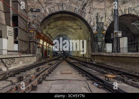 Ein beeindruckender Blick auf zwei parallele Tunnel am Bahnhof Rossio in Lissabon. Die industrielle, schroffe Umgebung mit ihren divergierenden Bahnen und rauen Texen Stockfoto