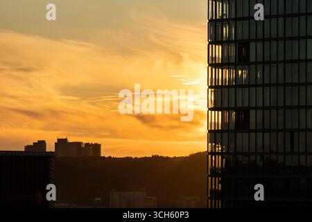 Modernes Geschäftsviertel bei Sonnenuntergang mit neuen Glashochhäusern und einer Skyline der Stadt, die Unternehmenswachstum und Stadtentwicklung symbolisieren Stockfoto