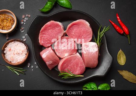 Ungekochtes Schweinefilet-Fleisch-Medaillons bereit zum Kochen, Blick von oben. Frische saftige Fleischstücke mit Salz, Kräutern und Gewürzen, Lebensmittelkonzept. Stockfoto