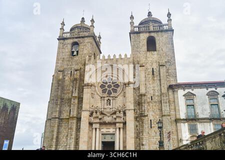 Porto, Portugal - 12.25.2022: Eine historische Kathedrale mit einer atemberaubenden Fassade und großen Steintreppen zum Eingang Stockfoto