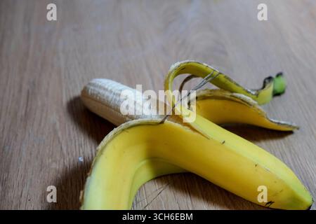 Köstliche frische Bananen auf einem Holztisch angeordnet Oberfläche geschälte Bananenhaut reife Frucht Faser gesund Stockfoto