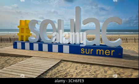 Blick auf den Hashtag Soulac-sur-Mer, riesige Buchstaben an einem Strand auf dem Hintergrund des blauen Himmels mit Wolken. Juni 2025. Soulac-sur-Mer, Medoc. Frankreich. Stockfoto