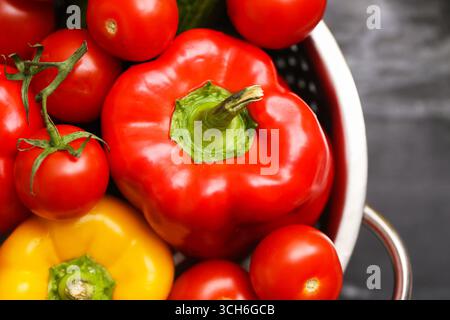 Frische rote Paprika in einer Schüssel. Bio-Gemüse mit grünen Stängeln. Gesunde Lebensmittelzutat zum Kochen. Natürliche Vitaminquelle mit lebendiger Farbe. Stockfoto