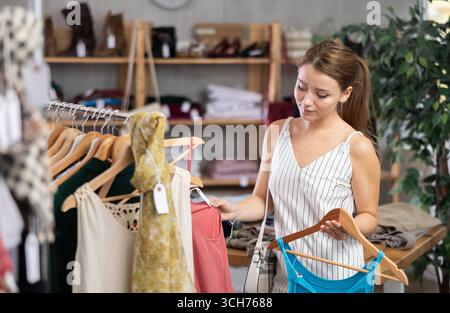 Die Frau wählt Kleidung aus der Sommerkollektion Stockfoto