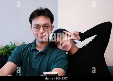 Glückliche Freunde posieren zusammen in einem Café mit lustigen Ausdrücken Stockfoto