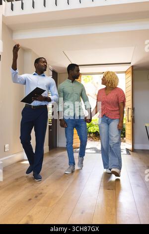 Immobilienmakler zeigt ein Paar modernes Zuhause, bespricht Funktionen und Optionen, Kopierraum Stockfoto