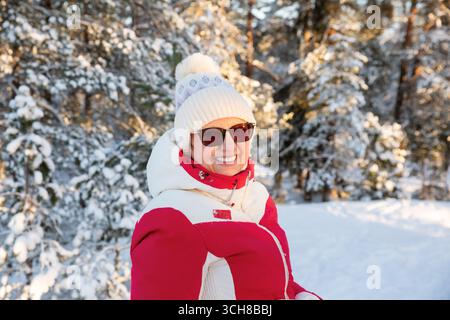 Porträt einer lächelnden Reifen Frau, die im Winter in die Kamera schaut und gesundes Altern, Vitalität, Wechseljahre Wellness und fröhlichen Lebensstil im Freien hervorhebt. Stockfoto