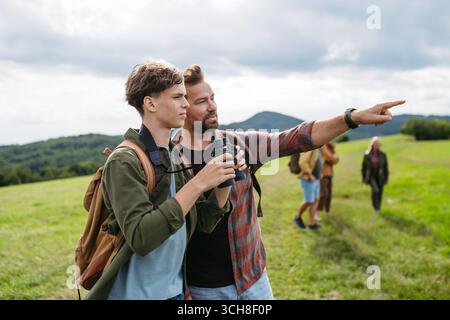 Vater-Showig, der in der Entfernung zum Sohn während des Wanderausflugs ist. Stockfoto