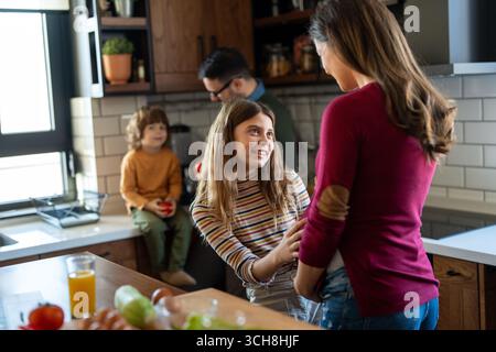 Glückliche Familie, die während des Wochenendfrühstücks Spaß in der Küche hatte. Glück, Schwangerschaft, Familienkonzept Stockfoto