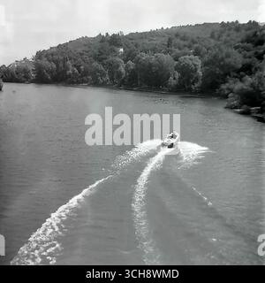 Eine dynamische Szene des Flusslebens am Sewerski Donets in Swiatohirsk in den 1970er-80er Jahren Der Rahmen zeigt verschiedene Schiffe, von Freizeitbooten und Flussbahnen voller Touristen bis hin zu schnellen Motorbooten, die sich vor der berühmten Landschaft der Heiligen Berge Lavra und Kreidehügel befinden. Das Foto vermittelt die Atmosphäre eines beliebten sowjetischen Resorts und ist ein anschauliches Zeugnis für den entwickelten Wassertourismus. Es ist ein nostalgisches Bild eines aktiven Sommerurlaubs und ein Symbol für das friedliche, unbeschwerte Leben im Donbass vor dem Krieg Stockfoto