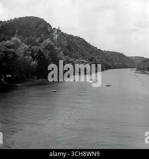 Eine dynamische Szene des Flusslebens am Sewerski Donets in Swiatohirsk in den 1970er-80er Jahren Der Rahmen zeigt verschiedene Schiffe, von Freizeitbooten und Flussbahnen voller Touristen bis hin zu schnellen Motorbooten, die sich vor der berühmten Landschaft der Heiligen Berge Lavra und Kreidehügel befinden. Das Foto vermittelt die Atmosphäre eines beliebten sowjetischen Resorts und ist ein anschauliches Zeugnis für den entwickelten Wassertourismus. Es ist ein nostalgisches Bild eines aktiven Sommerurlaubs und ein Symbol für das friedliche, unbeschwerte Leben im Donbass vor dem Krieg Stockfoto